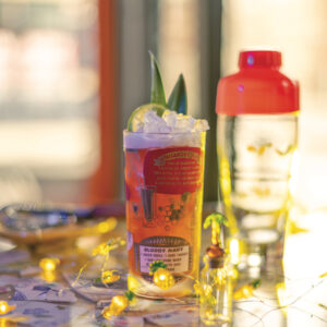 A fun tiki cocktail sits on a colorful bar top