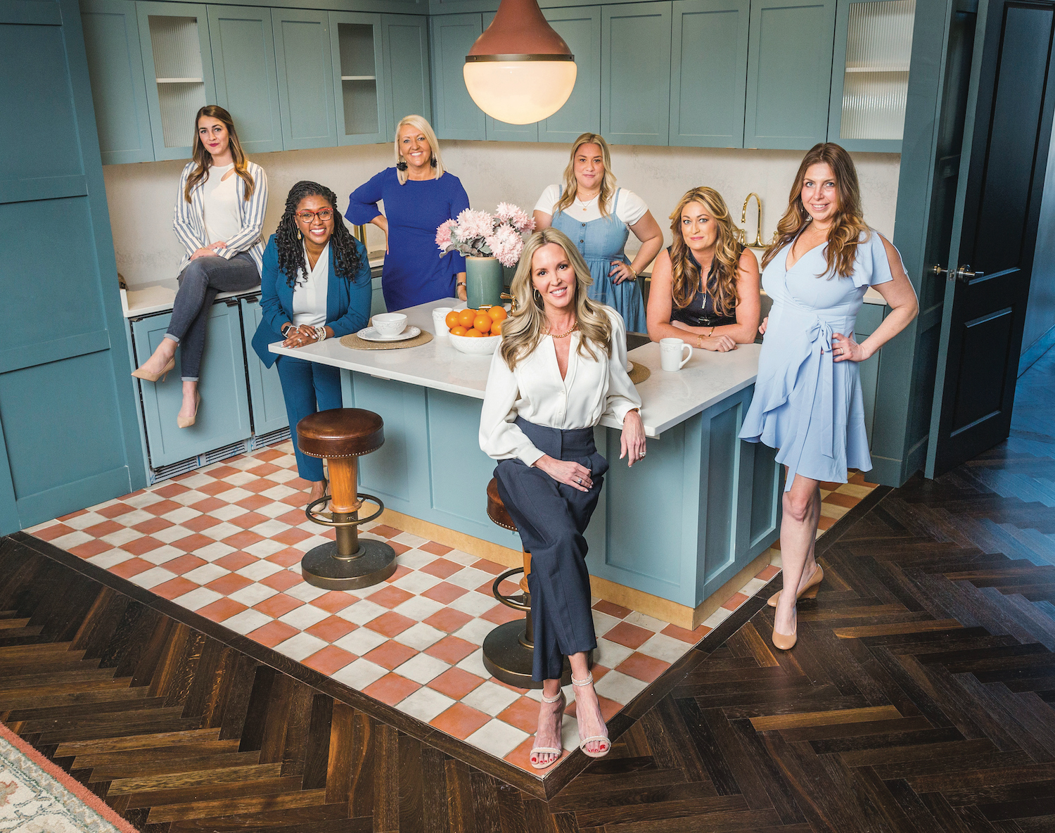 Team Herr color coordinates their outfits in shades of blue, seated in a 1950's styled kitchen smiling at the camera